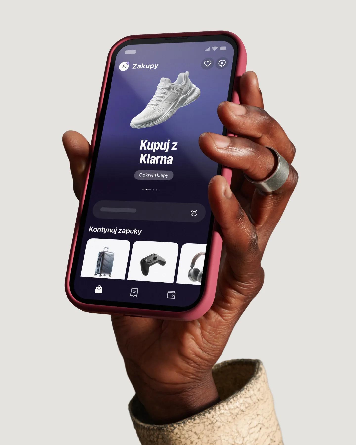 Hand holding phone with the Klarna app on the screen