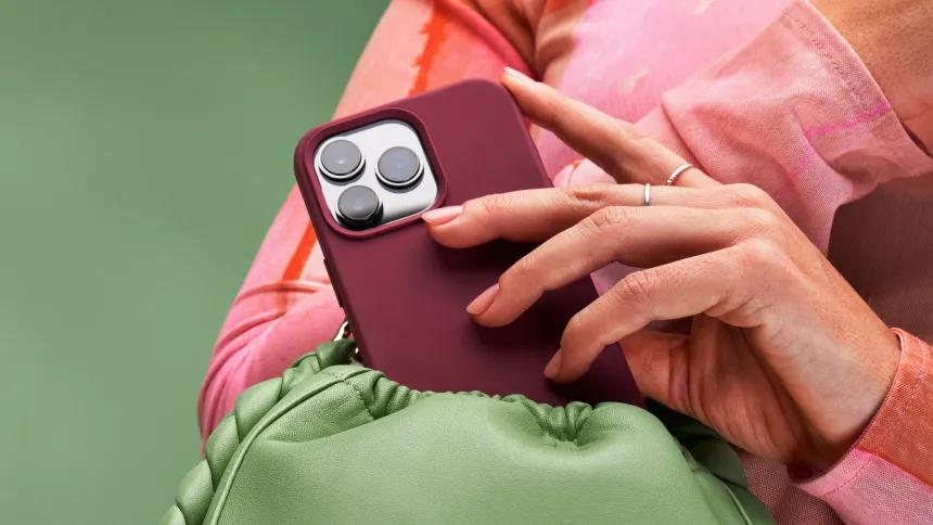 Body holding a phone with a dark red phone case