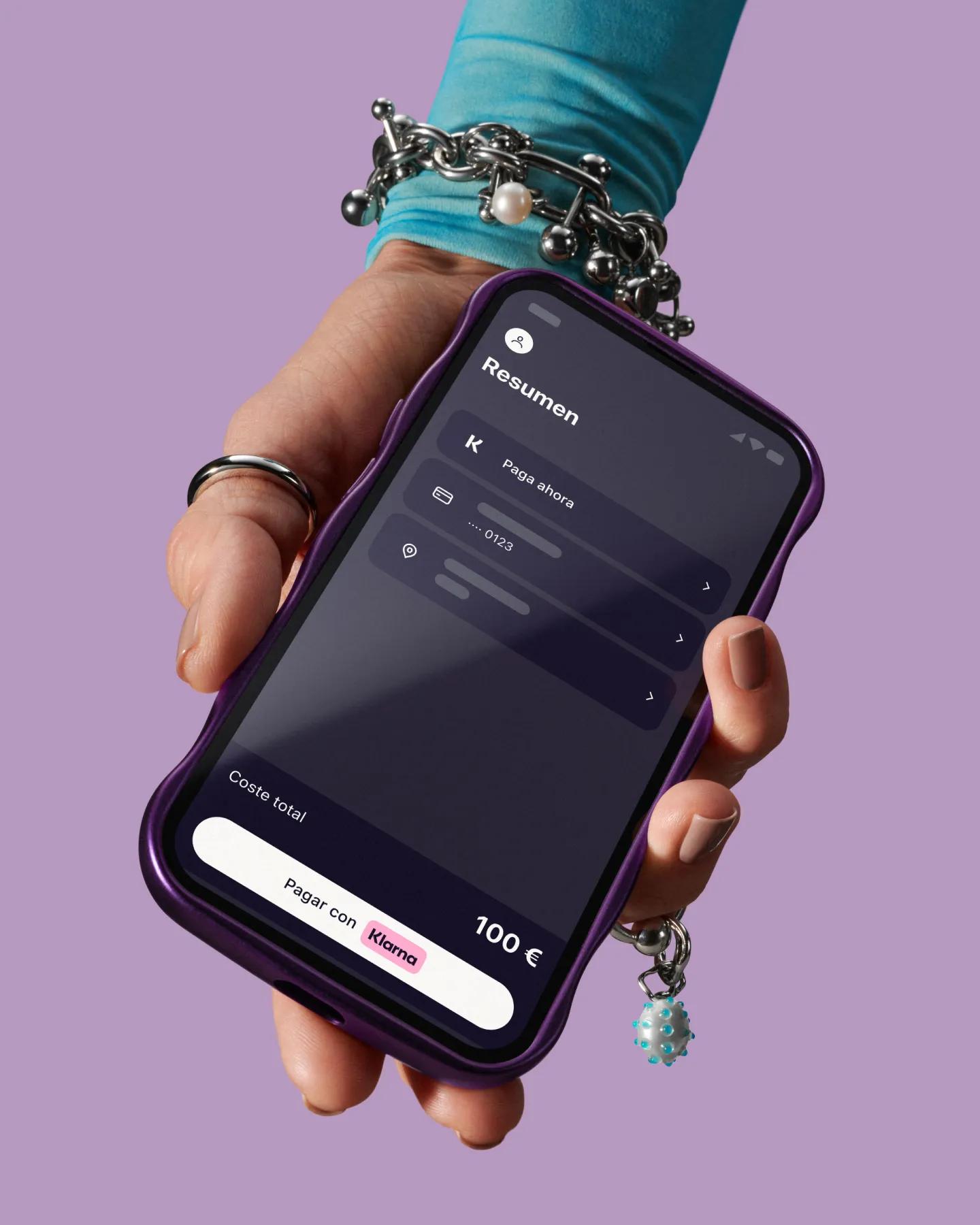 Hand holding phone with Klarna app open