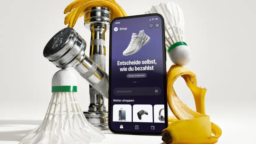 Phone with klarna app in front of artistically styled sport atributes