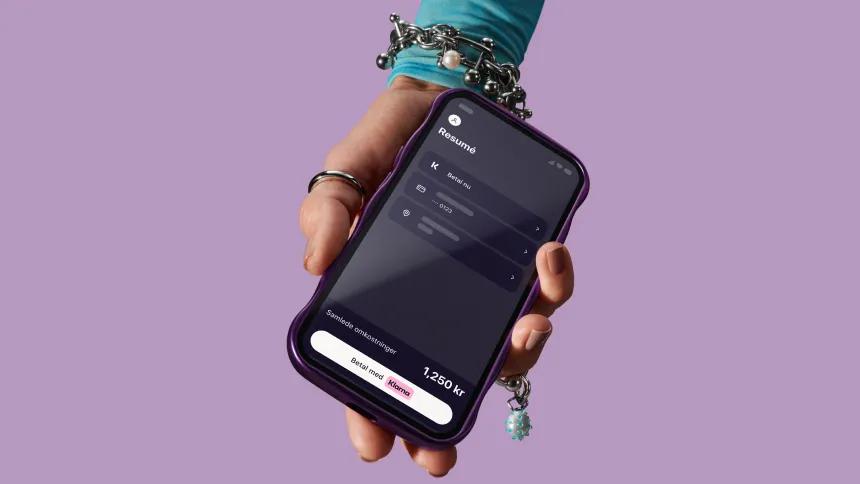 Hand holding phone with Klarna app open