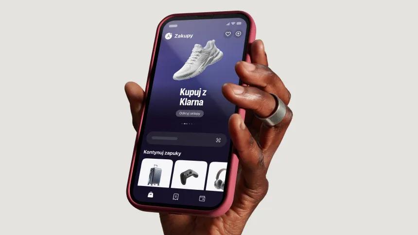 Hand holding phone with the Klarna app on the screen