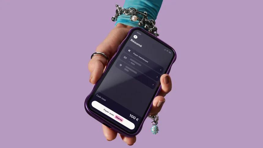 Hand holding phone with Klarna app open