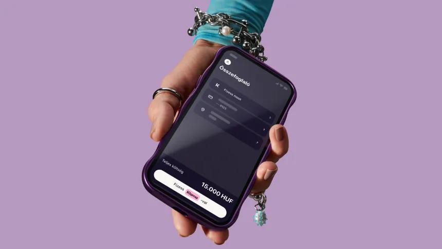 Hand holding phone with Klarna app open