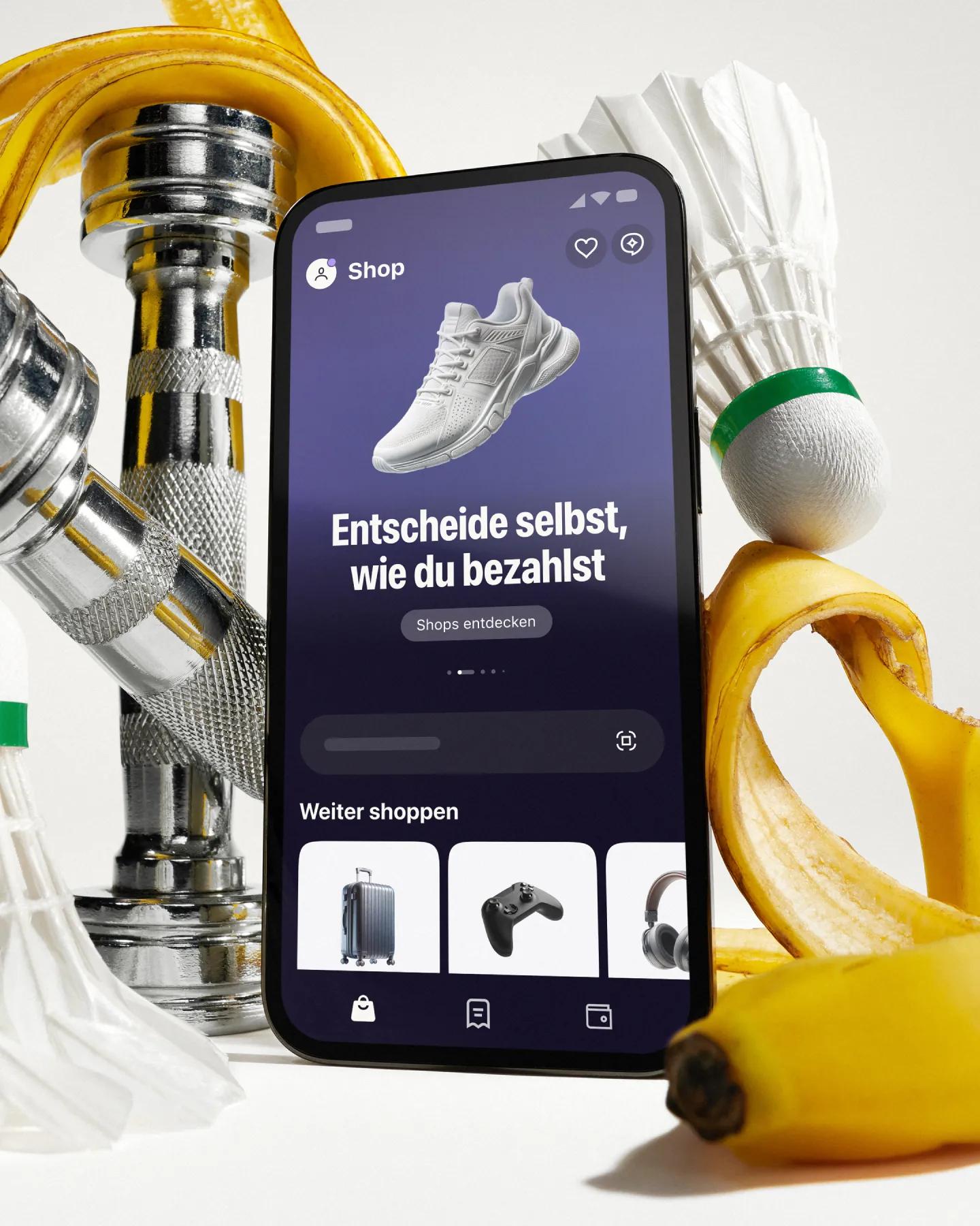 Phone with klarna app in front of artistically styled sport atributes