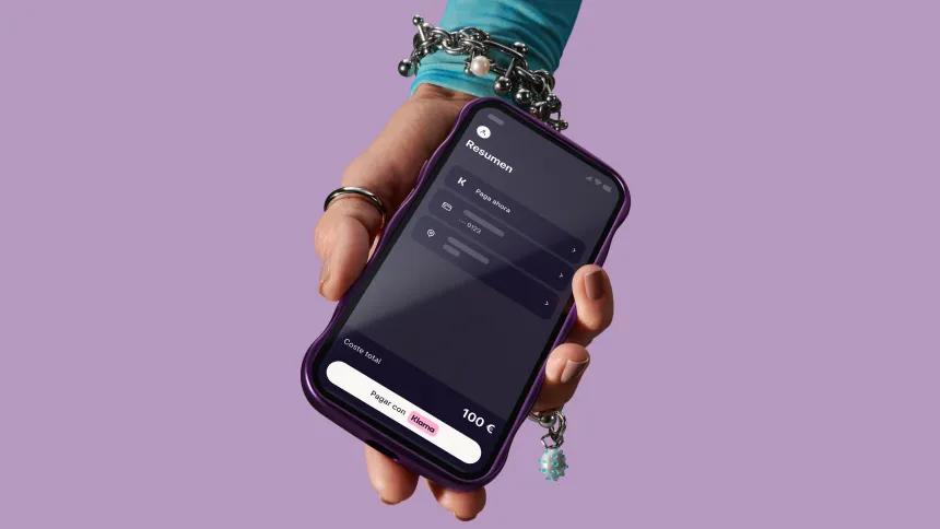 Hand holding phone with Klarna app open