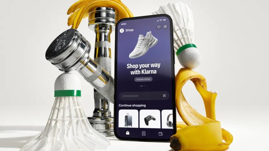 Phone with klarna app in front of artistically styled sport atributes