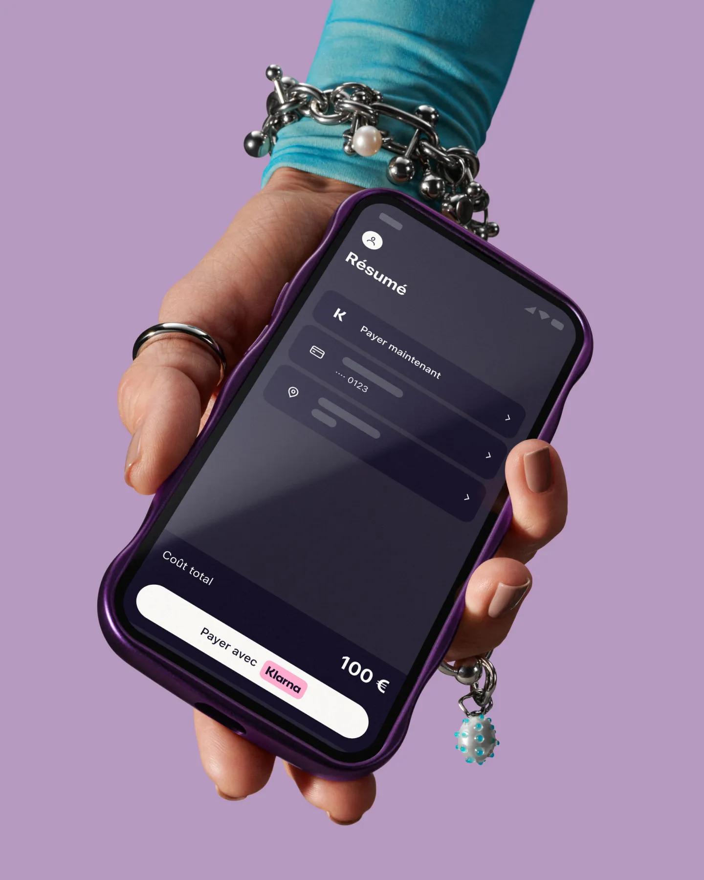 Hand holding phone with Klarna app open